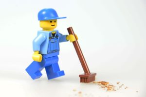 Lego man with broom cleaning 